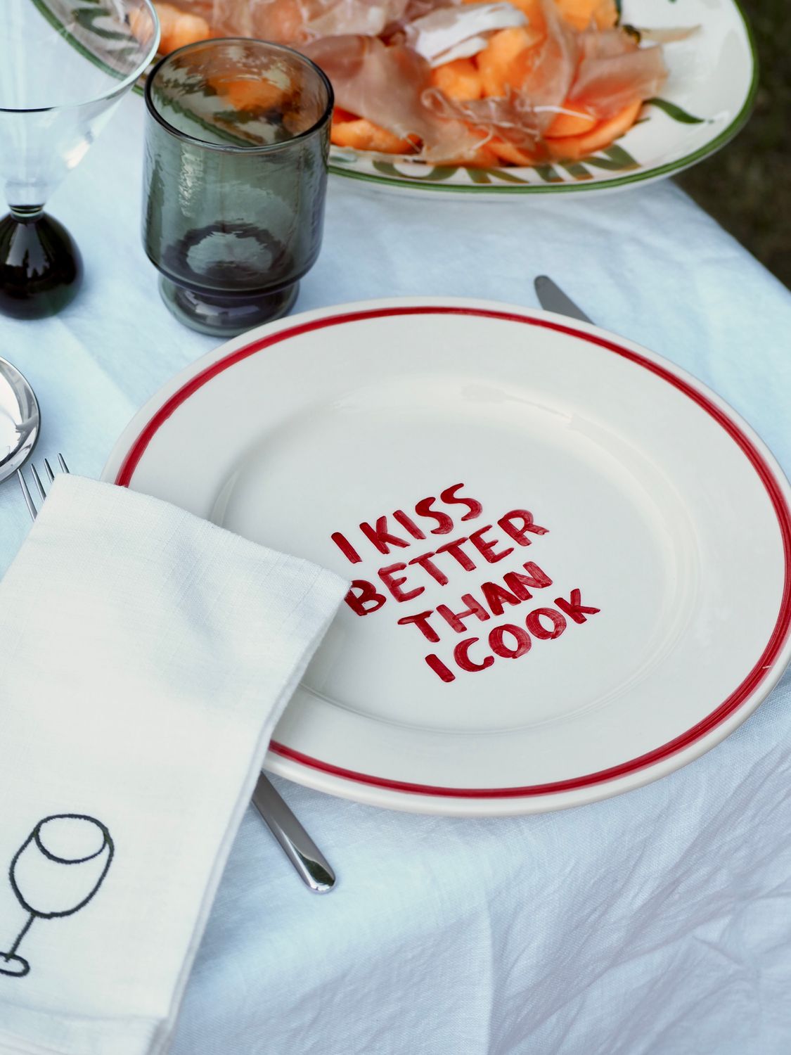 'I kiss better than I cook' bord — ø27cm