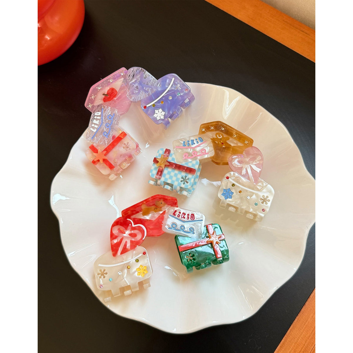 Likio Whimsical Holiday haarklemmetjes op een witte schaal