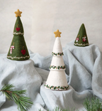 Vilten kerstbomen van Gry & Sif in groen en wit met gouden sterren op een lichtblauwe doek