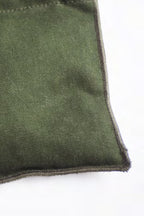 Detail van de hoek en stiksels van de kaki onderzetter met kersenpitten van Ensemble