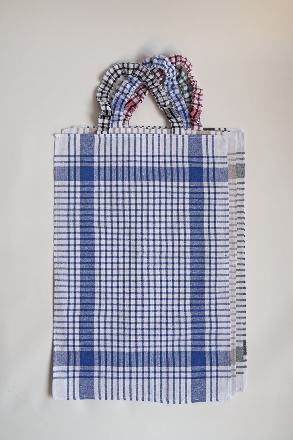 Bavet voor volwassenen van Ensemble in blauw geruite torchon met geruite halsband, plat gefotografeerd