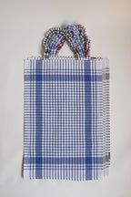Bavet voor volwassenen van Ensemble in blauw geruite torchon met geruite halsband, plat gefotografeerd