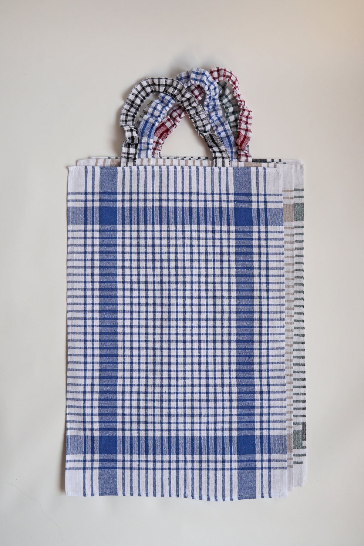 Bavet voor volwassenen van Ensemble in blauw geruite torchon met geruite halsband, plat gefotografeerd